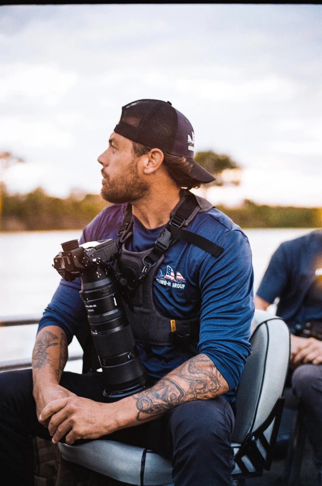 Nic Lombardo seated aboard a boat with a camera and telephoto lens